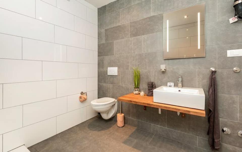Fertig renoviertes Badezimmer nach Bauabnahme – Ergebnis einer Hausrenovation in der Schweiz